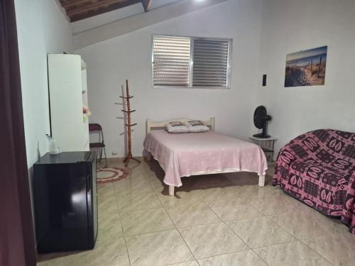 een slaapkamer met een bed en een koelkast bij Casa na mata ceu iluminado in Guararema