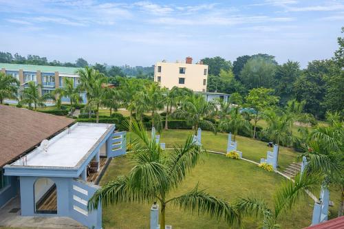 een luchtzicht op een park met palmbomen en een gebouw bij Corbett Selva Resort By DevStayZ in Rāmnagar
