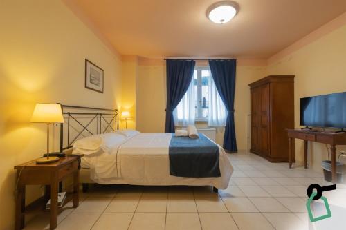 a bedroom with a bed and a flat screen tv at Hotiday Toscana Riparbella in Riparbella
