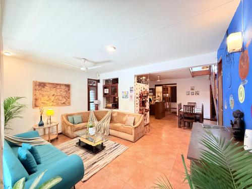 een woonkamer met een bank en een tafel bij Jugglers Rest Boho Style 4BHK Spacez Luxury Villa with Terrace Lounge in Bangalore