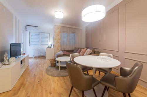 un salon avec une table et un canapé dans l'établissement NAR Royalton Accommodation, à Niš