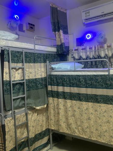 two bunk beds in a room with blue lights at OST Homes Rolla Park in Sharjah