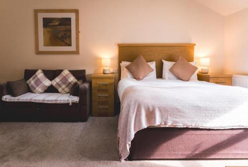 a bedroom with a large bed and a couch at The Horse & Farrier in Otley