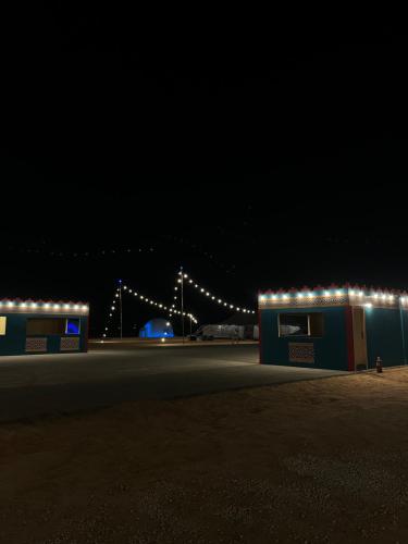 ein Gebäude mit Lichtern in der Nacht in der Unterkunft خيم مبيت ملكية بالصياهد in Rumāḩ