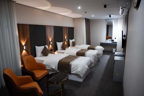 ein Hotelzimmer mit zwei Betten und einem Fernseher in der Unterkunft Wlat Hotel in Erbil