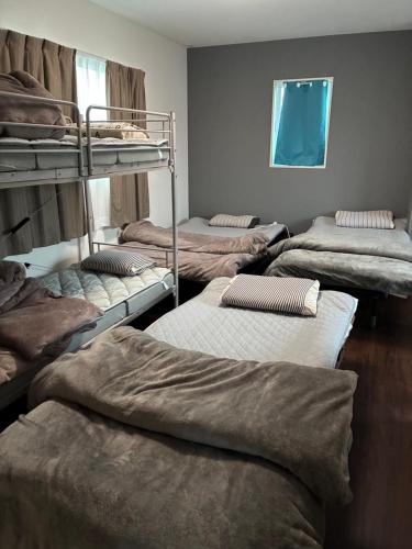 a room with several bunk beds in a room at 智翔はうす 駐車場無料 民泊で女性家主滞在型 予約後はメール確認願います in Kumamoto