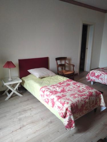 a bedroom with a bed and a table with a lamp at La Cochetière in Cheviré-le-Rouge