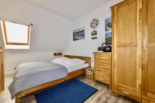 a bedroom with a bed and a wooden cabinet at Ferienwohnung AHOI Thiessow in Thiessow