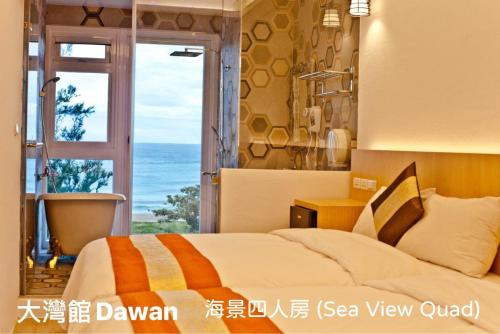 een slaapkamer met een bed en uitzicht op de oceaan bij Kenting Dawan Homestay in Kenting