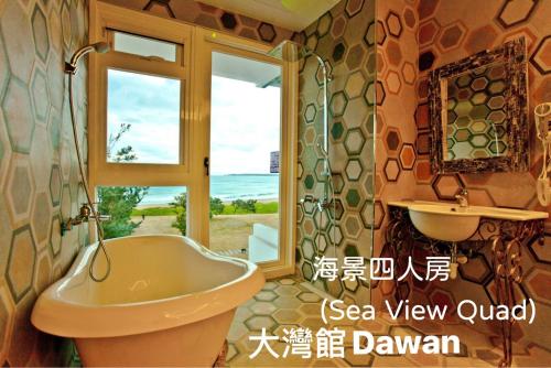 een badkamer met een bad, een wastafel en een raam bij Kenting Dawan Homestay in Kenting