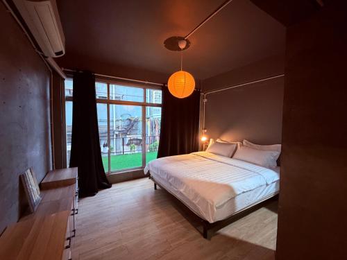 a bedroom with a bed and a large window at WSTAR Hostel in Bangkok