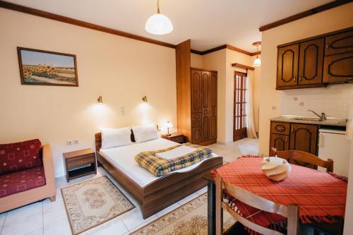 una camera da letto con un letto, un tavolo e una cucina di Studios ΕΥΤΥΧΙΑ-6 a Kalavrita