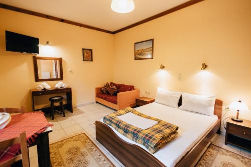 una camera da letto con un letto, una scrivania e un divano di Studios ΕΥΤΥΧΙΑ-6 a Kalavrita