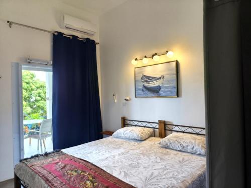 - une chambre avec un lit doté d'un rideau bleu et d'une fenêtre dans l'établissement El-Sangha Studio 2mina pieds de la plage de baie du cap, à Ruisseau Créole