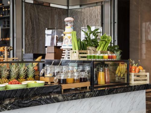 a buffet line with drinks and fruits and vegetables at Pullman Jiaxing Pinghu Excellence in Jiaxing