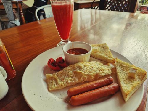 a plate of breakfast food with hot dogs and toast at Stone Town Cafe in Zanzibar City