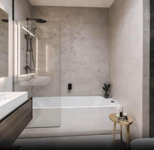 een badkamer met een bad en een glazen douche bij Victoria Residences in St Ives