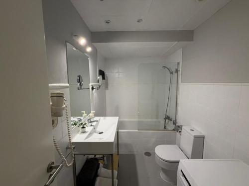 een witte badkamer met een wastafel en een toilet bij Smartmonki Sinagoga Entre la Catedral y Zocodover in Toledo