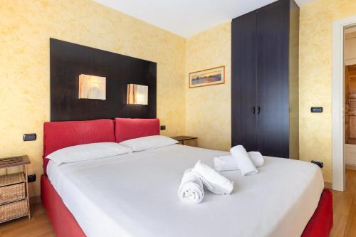 a bedroom with a large white bed with red accents at Hostdomus - Nube d'Argento in Sestriere