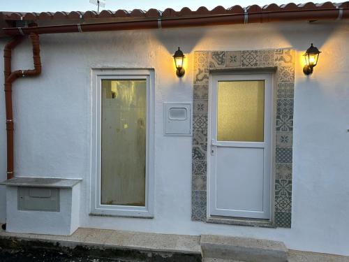 a white house with a door and a window at Refúgio do Ribeirinho in Paredes de Coura