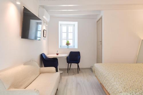 a bedroom with a bed and a table and chairs at Galaxidaki στην Πλατεία in Galaxidhion