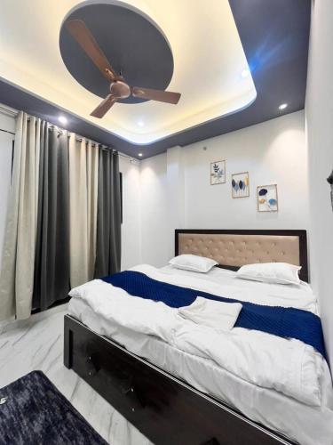 a bedroom with a bed with a ceiling fan at Captains cabin in Tikri Kalān