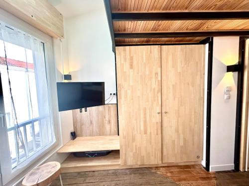 een kamer met een grote houten kast en een flatscreen-tv bij Mezzanines 50 m de la plage in Châtelaillon-Plage