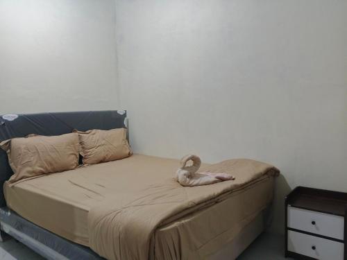 a bed with a swan sitting on top of it at Sherin Homestay in Pulau Sarang