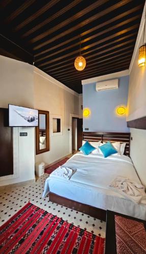 a bedroom with a large bed and a flat screen tv at Dar Karaouyine Panoramic in Fez