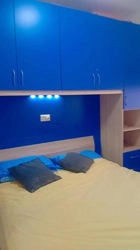 a blue room with a bed with blue cabinets at D-Onyx Holiday lets Apartment in Żebbuġ