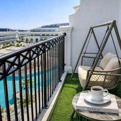 a balcony with a table and a cup of coffee at 1BR Lagoon View Luxury Spa Retreat near Miracle Garden By Green Sky Holiday Homes in Dubai