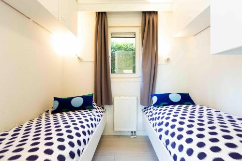 two beds in a small room with a window at Recreatiepark het Esmeer in Aalst