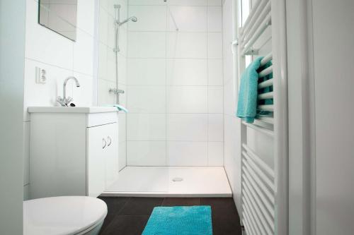a white bathroom with a toilet and a shower at Recreatiepark het Esmeer in Aalst