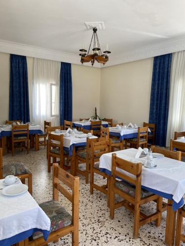 une salle à manger avec des tables et des chaises avec des tables bleues et blanches dans l'établissement Babis Hotel, à Karterados