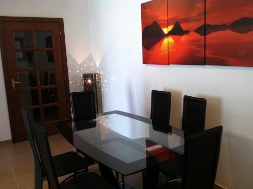 a dining room with a glass table and chairs at Casa Tedi, Alto do Perogil, Tavira - 3 Bedroom, 3 Bathroom villa, large Pool, exquisite Gardens & Air-conditioning in Tavira