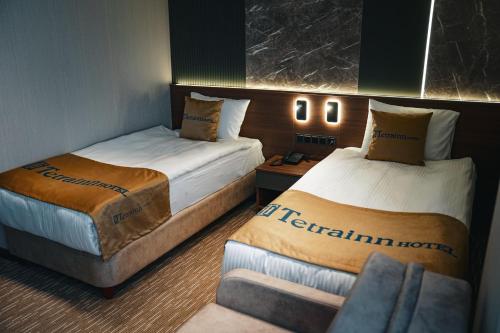 ein Hotelzimmer mit zwei Betten und einer Couch in der Unterkunft Tetrainn Hotel in Ankara