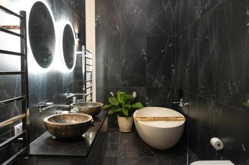 ein Badezimmer mit zwei Waschbecken und einem WC. in der Unterkunft Jodha Bai Retreat in Terranora