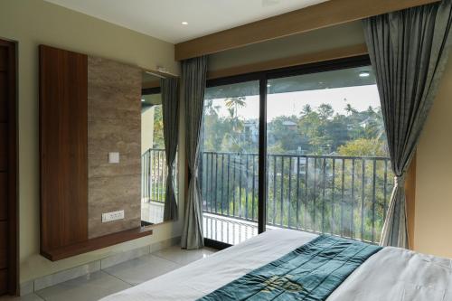 a bedroom with a bed and a large window at Rasha Suites in Kalpetta