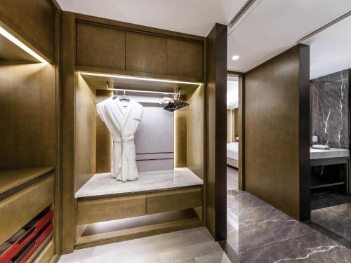 a dressing room with a white shirt on a hanger at Swissôtel Shenyang in Shenyang