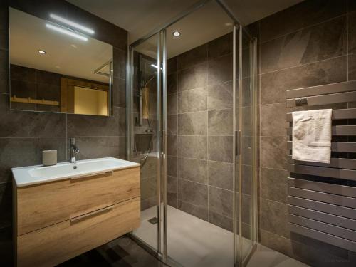 een badkamer met een wastafel en een douche bij Les Doliges - OVO Network in Les Gets