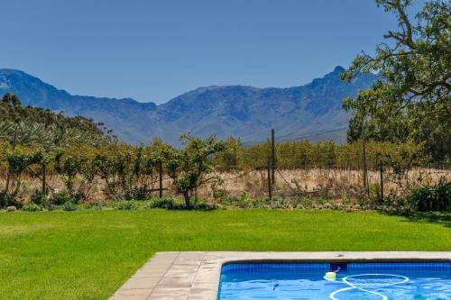 - une piscine dans une cour avec des montagnes en arrière-plan dans l'établissement De Hoop Farm - mountain view, à Breërivier