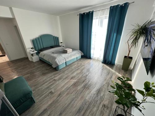 a bedroom with a bed and blue curtains at Garsoniera lux in Craiova
