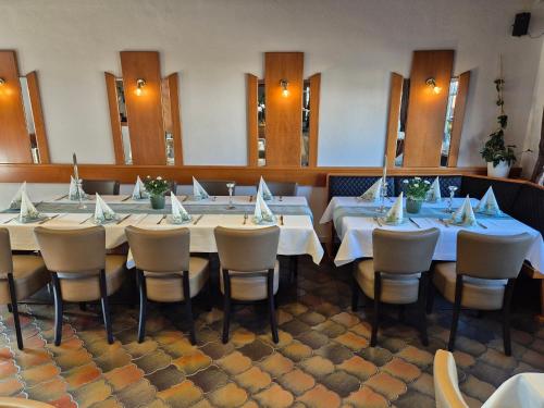 een eetkamer met een lange tafel en stoelen bij Hotel Restaurant Neffelthal in Kerpen