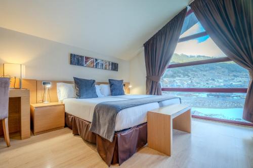 een slaapkamer met een groot bed met een groot raam bij Wuau! Hotel Galanthus & Spa in Soldeu