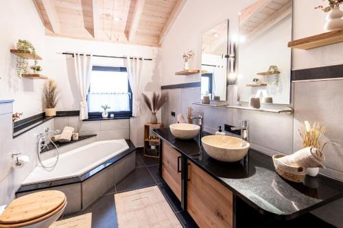 a bathroom with two sinks and a tub at Riedbach-Lodge 3 in Viechtach