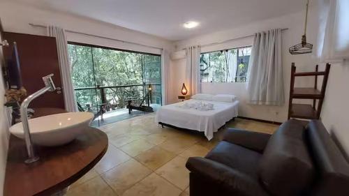 een slaapkamer met een bed, een bank en een bad bij Ninhos da Pipa in Pipa