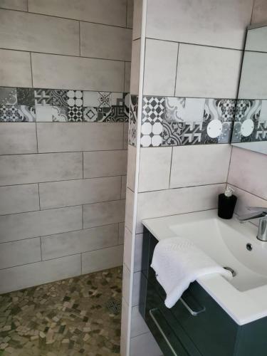 een badkamer met een wastafel en een spiegel bij Camping Hôtel Les Airelles Montagne Ardéchoise in Saint-Cirgues-en-Montagne