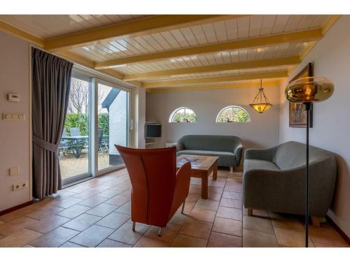 een woonkamer met een bank en een tafel bij Lovely Holiday Home in Texel near Sea in Oost