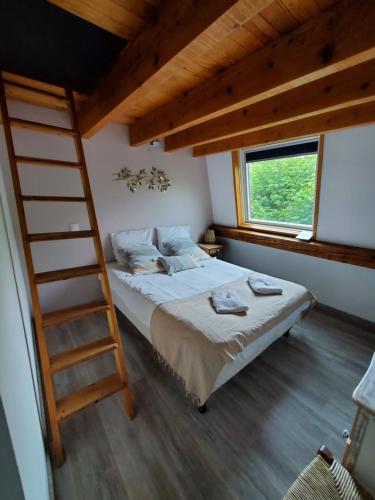 een slaapkamer met een stapelbed en een ladder bij Camping Hôtel Les Airelles Montagne Ardéchoise in Saint-Cirgues-en-Montagne