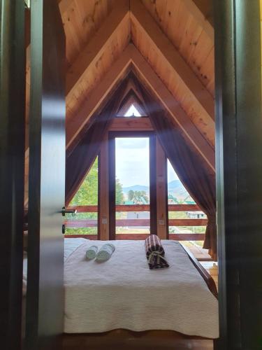 un letto in una stanza con una grande finestra di Highlander guesthouse a Žabljak